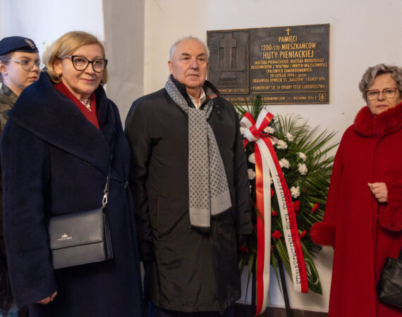 Małgorzata Gośniowska-Kola przy tablicy upamiętniającej zbrodnie w Hucie Pieniackiej